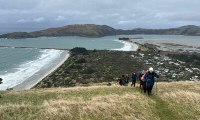 Battling the strong NE wind up Heyward Point track. Caption and photo Pam